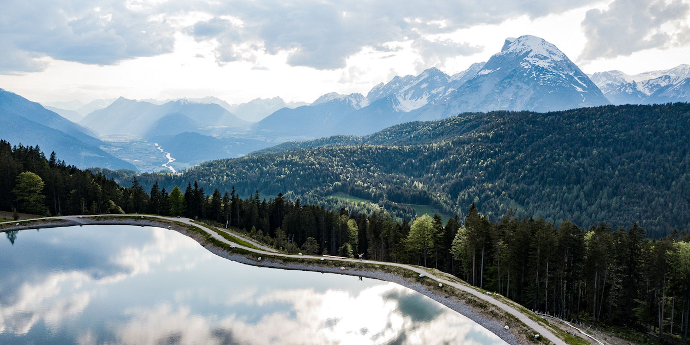 Bergsee bei Mösern mit Spiegelung und Blick auf die Hohe Munde über dem Inntal